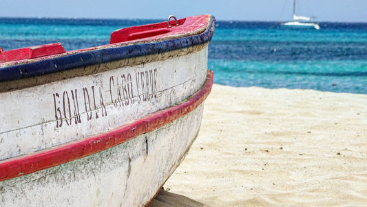 Foto panoramica di Capo Verde: Spiaggia di sabbia dorata con palme e un mare turchese sotto un cielo azzurro. Un'immagine mozzafiato delle bellezze naturali di Capo Verde.